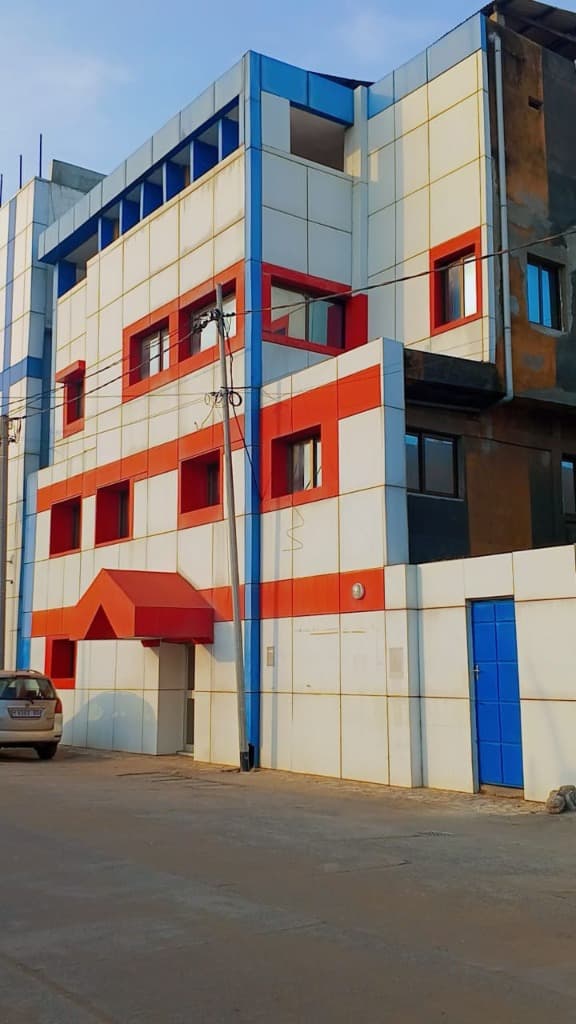 Façade bleu, blanc et rouge du bâtiment de l'Hôtel École Avenida à Lomé
